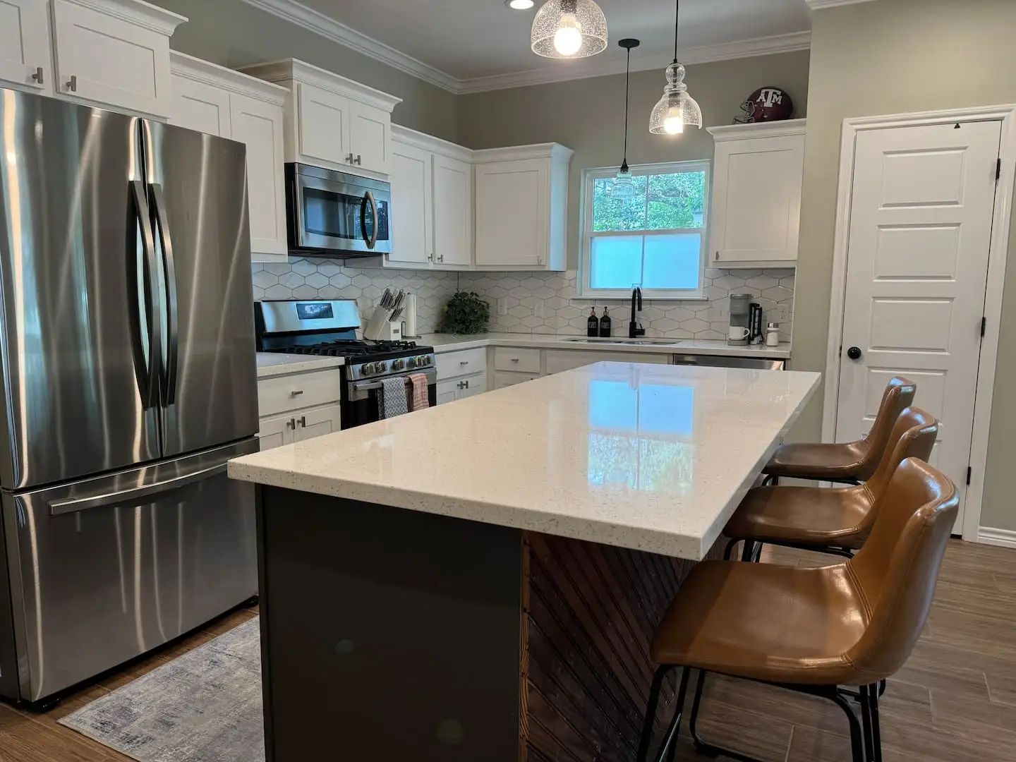 Kitchen with fridge, island, and pendant lights
